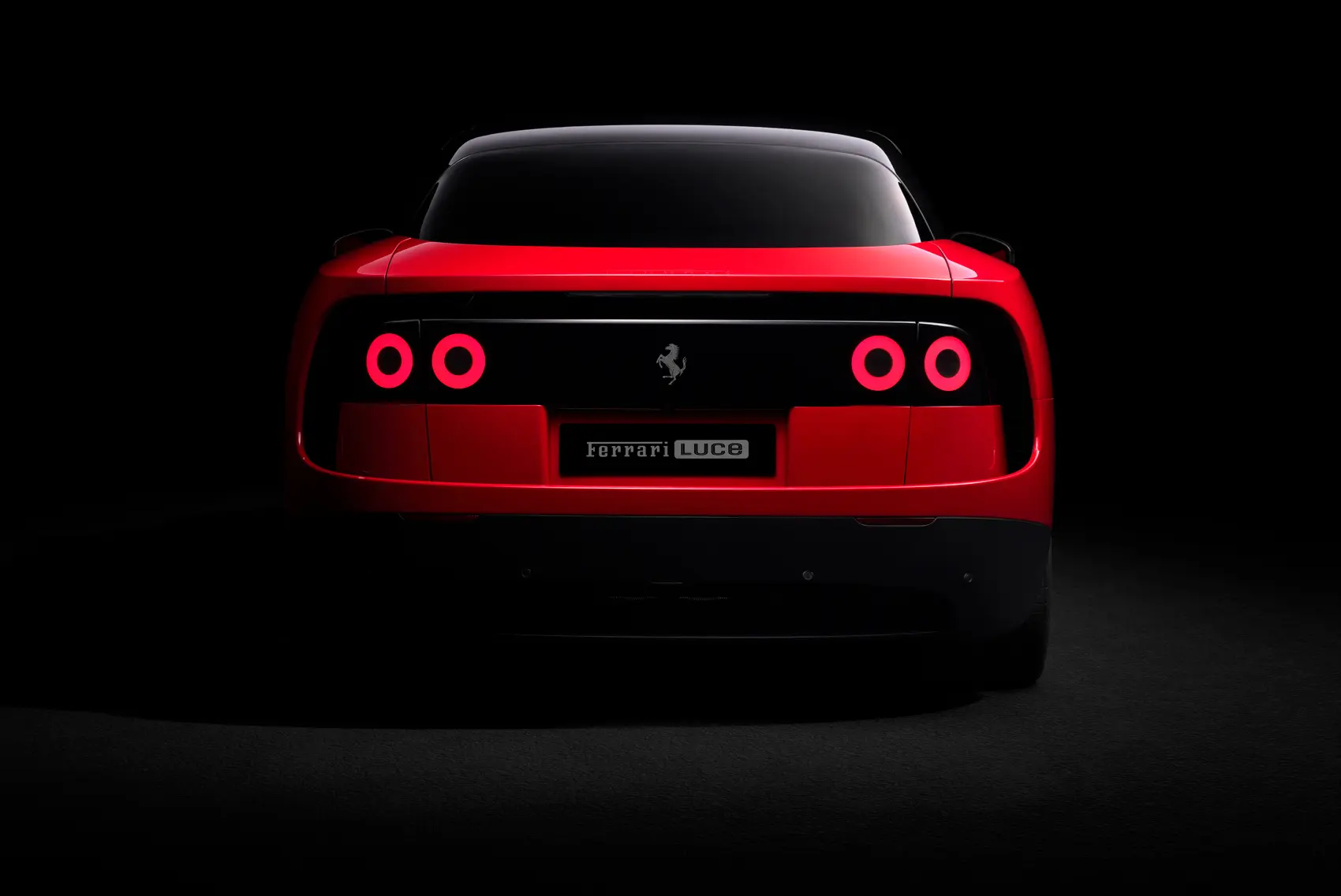 Ferrari Luce in red from the rear, with four round taillights set in a black band that spans the full width of the tail
